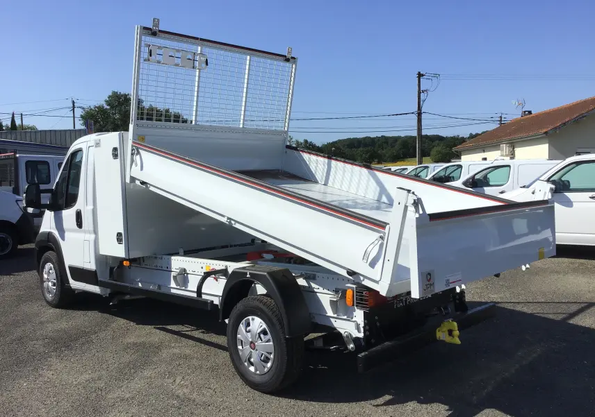 FIAT Ducato Chassis Benne blanc vu en 3/4 arrière avec benne acier JPM relevée et cabine simple.
