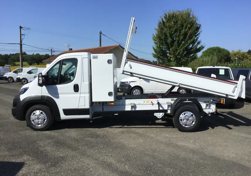 FIAT Ducato Chassis Benne blanc vu de profil côté gauche, benne acier JPM relevée et coffre latéral blanc visible.