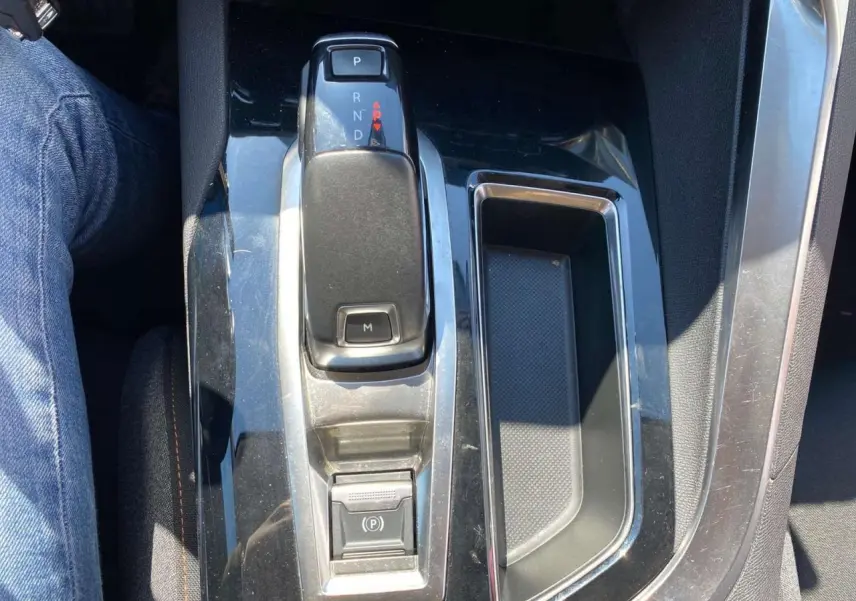 Vue rapprochée de la console centrale du Peugeot 5008 gris clair, avec levier de boîte auto et rangement adjacent.