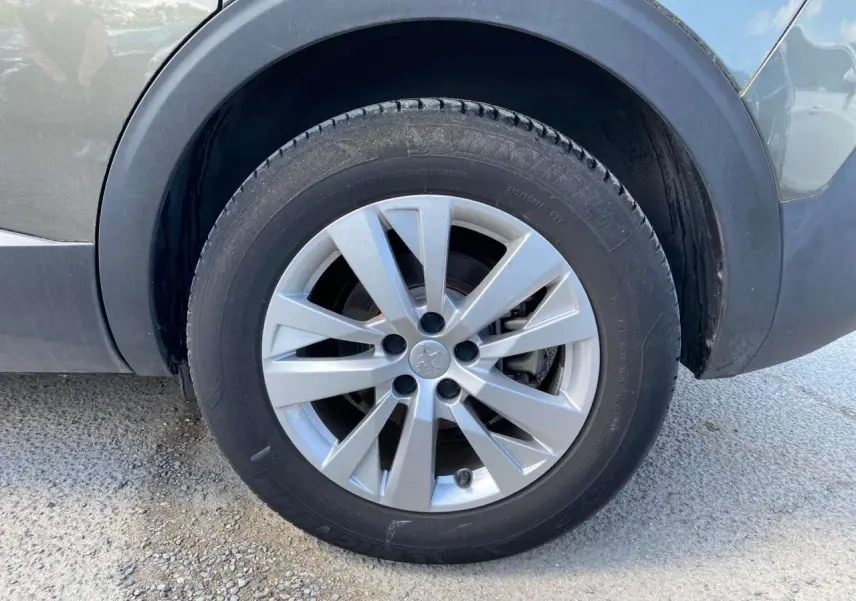 Gros plan sur la roue avant gauche gris clair du Peugeot 5008 2019 avec jante alliage à 5 branches doubles.