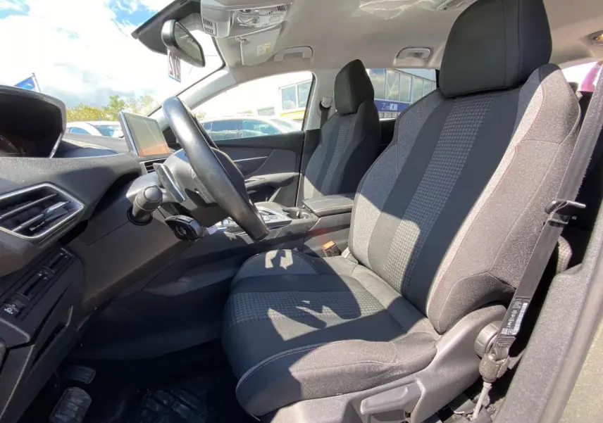 Vue intérieure côté conducteur du Peugeot 5008 gris clair de 2019, mettant en valeur la sellerie tissu et le tableau de bord moderne.
