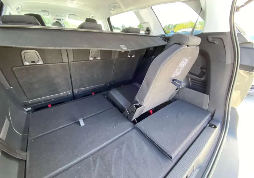 Vue arrière du coffre du Peugeot 5008 gris clair avec siège rabattable et banquette arrière en tissu noir.
