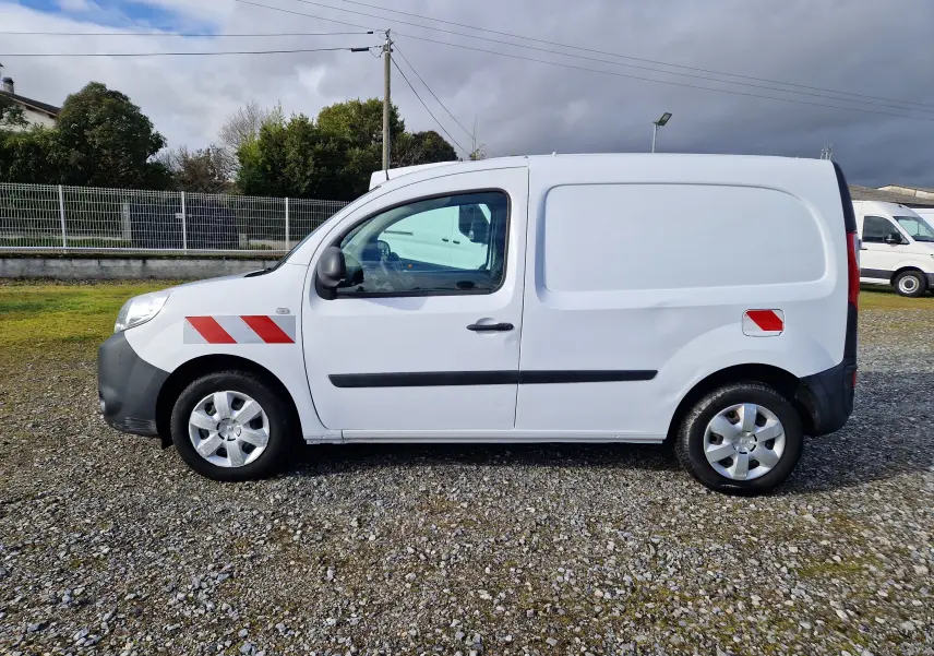 Vue de profil côté gauche d’un Renault Kangoo blanc 2020 utilitaire avec bandes rouges réfléchissantes sur l’aile avant et arrière.