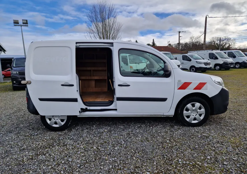 Vue de profil droit d’un Renault Kangoo blanc 2020 avec porte latérale coulissante ouverte montrant l’aménagement intérieur en bois.