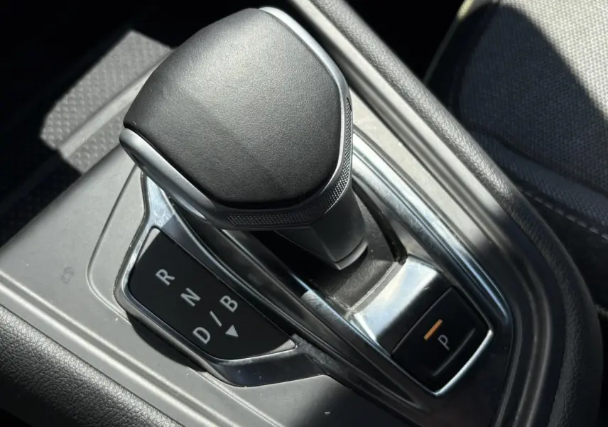 Le levier de vitesses automatique noir de la Renault SYMBIOZ E-Tech vu en gros plan dans la console centrale.