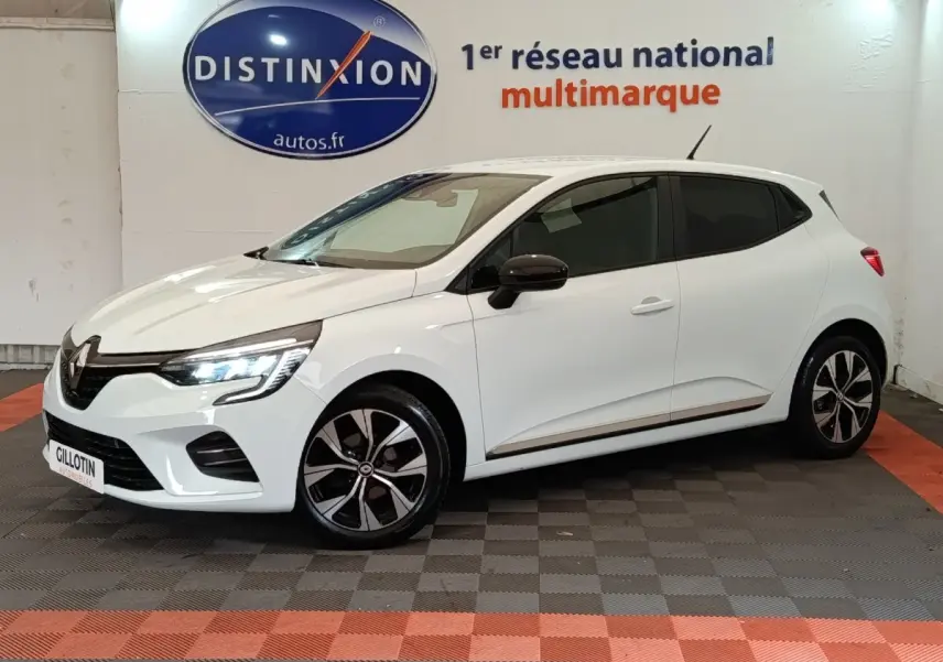 Renault Clio Evolution TCe 90 blanche vue en 3/4 avant droit, avec phares LED allumés et jantes noires bicolores.