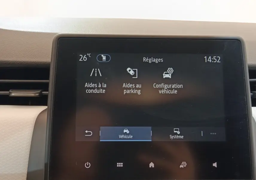 Écran tactile central de la Renault Clio blanc 2023 affichant les réglages d’aides à la conduite et parking.