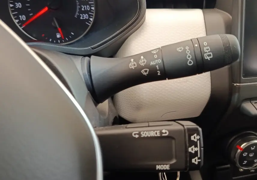Gros plan sur les commandes de volant et tableau de bord beige clair de la Renault Clio Evolution TCe 90 2023.