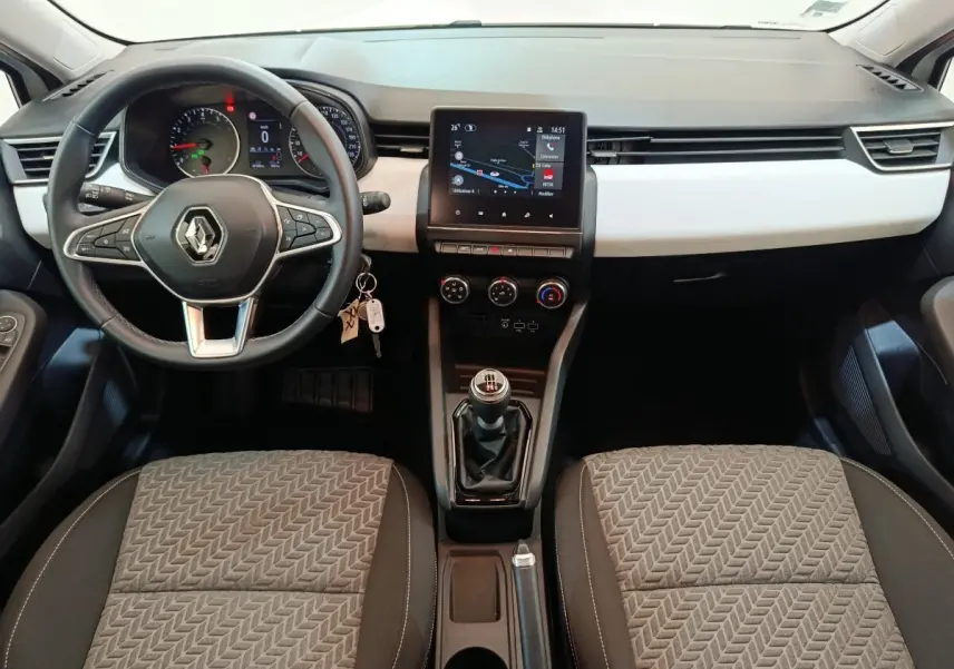Vue intérieure avant de la Renault Clio Evolution TCe 90 2023 avec volant cuir multifonctions et écran tactile central.