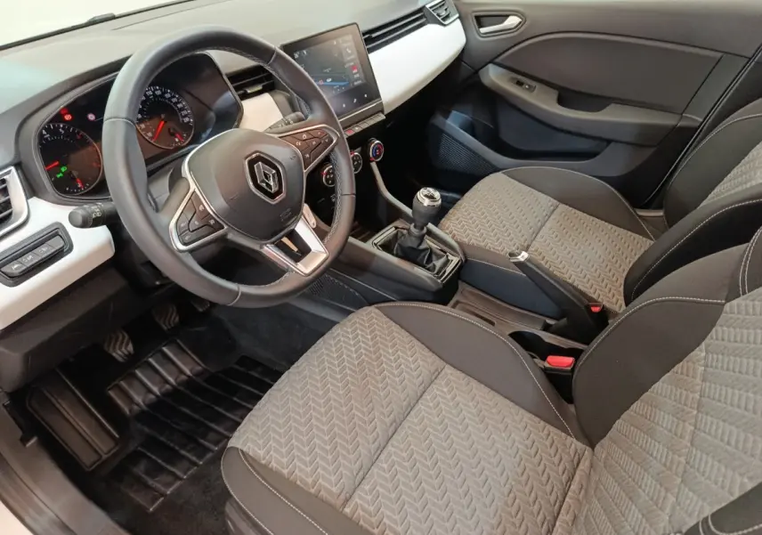 Intérieur de Renault Clio Evolution TCe 90 2023, vue côté conducteur, volant cuir multifonctions et écran tactile central.