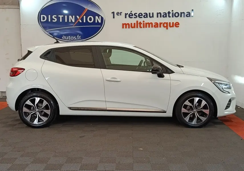 Profil gauche d'une Renault Clio Evolution TCe 90 blanche 2023 avec jantes alliage et rétroviseurs noirs.