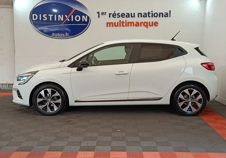 Profil droit d'une Renault Clio Evolution TCe 90 blanche 2023 avec jantes alliage et rétroviseurs noirs.