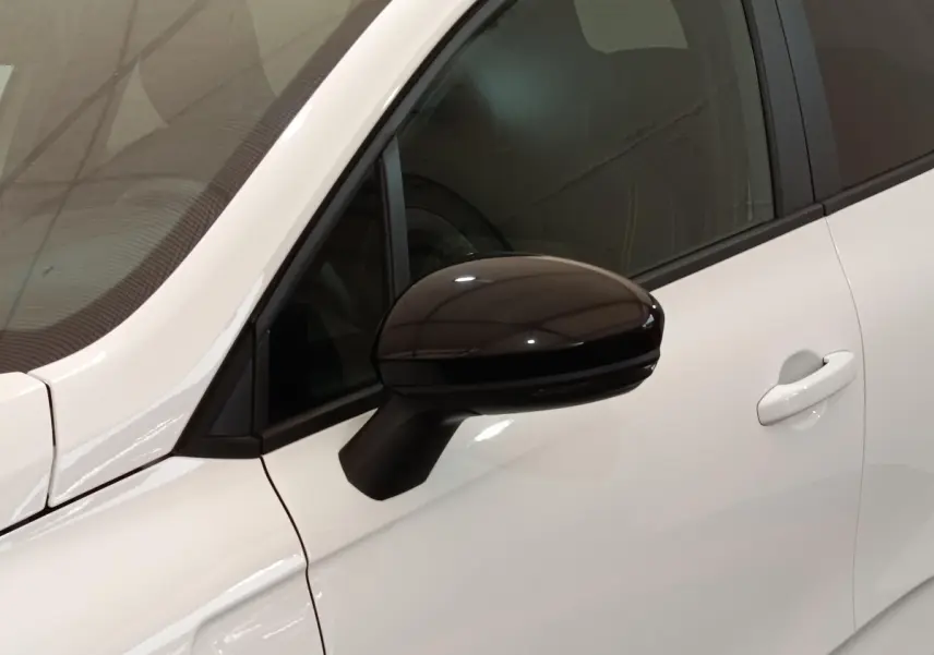 Gros plan sur le rétroviseur noir côté gauche d'une Renault Clio Evolution TCe 90 blanche de 2023.