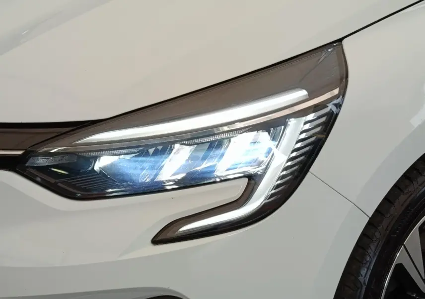 Gros plan sur le phare avant droit LED d'une Renault Clio Evolution TCe 90 blanche de 2023.