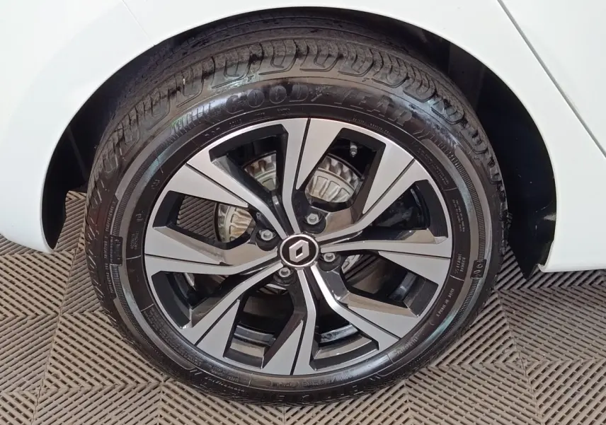 Gros plan sur la roue avant droite d'une Renault Clio blanche, avec jante alliage bicolore et pneu Goodyear.
