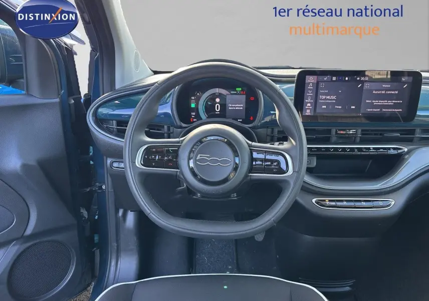 Vue intérieure centrée sur le volant et tableau de bord de la FIAT 500 électrique 2023, finition noir avec touches vert océan.
