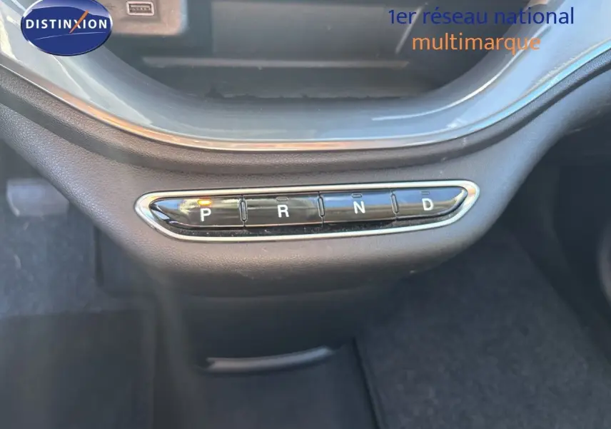 Gros plan sur la commande de boîte automatique avec boutons P, R, N, D allumée, intérieur noir de la Fiat 500 électrique 2023.