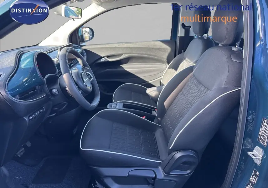 Intérieur côté conducteur de la FIAT 500 Electrique 2023 en vert océan, sièges tissu noir avec surpiqûres blanches.