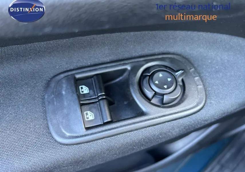Gros plan sur les commandes de réglage des rétroviseurs et vitres côté conducteur d'une FIAT 500 électrique vert océan 2023.