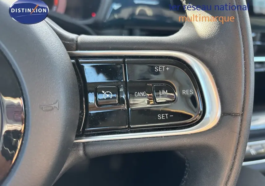 Gros plan sur les commandes de régulateur de vitesse au volant cuir d'une FIAT 500 électrique 2023.