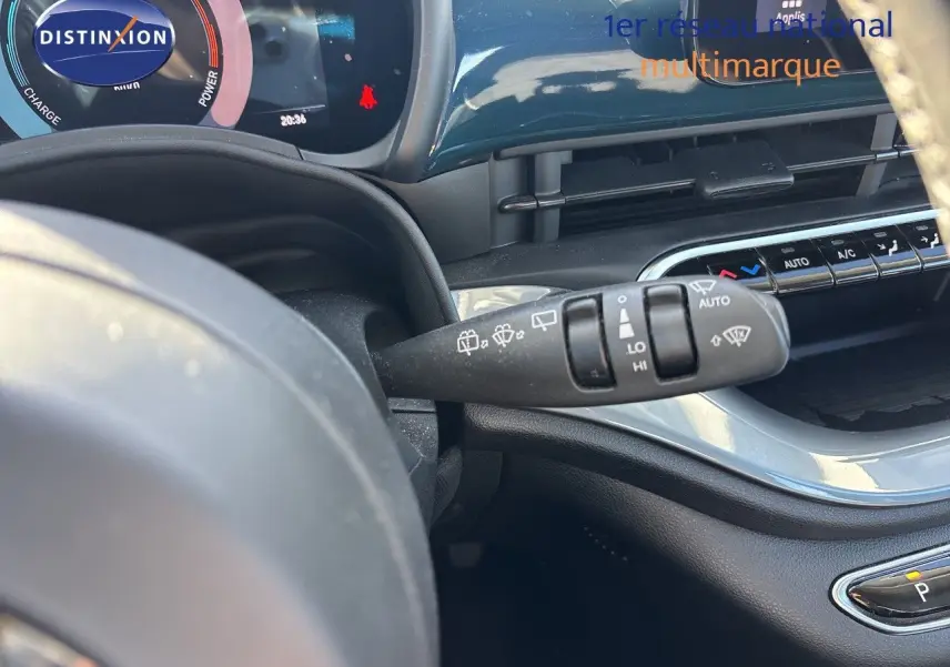 Vue intérieure du combiné d'instruments et du commodo d'essuie-glace de la Fiat 500 électrique vert océan 2023.