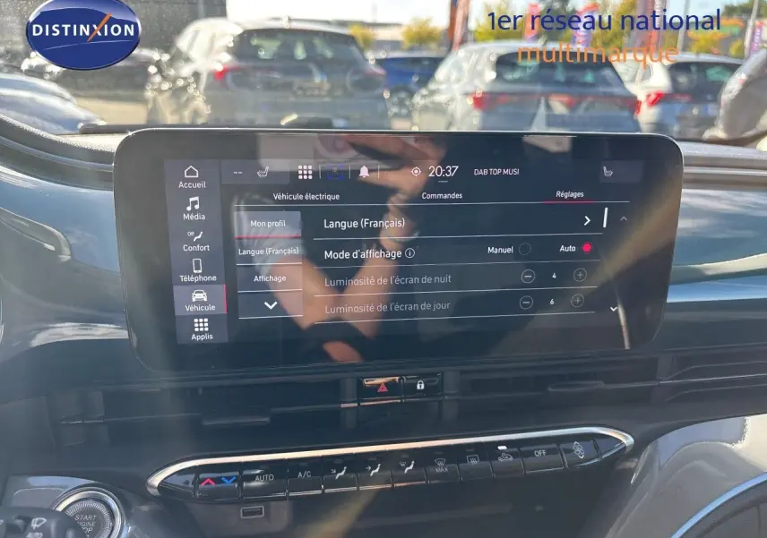 Vue rapprochée de l'écran tactile central du tableau de bord de la Fiat 500 électrique 2023, avec commandes climatisation visibles.