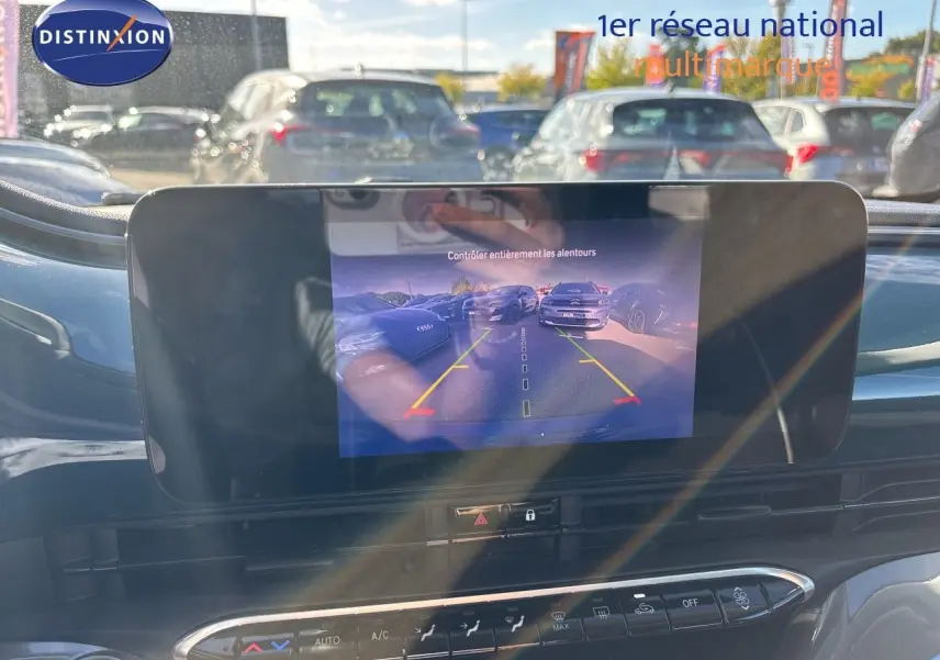 Écran tactile affichant la caméra de recul dans l’habitacle d’une Fiat 500 électrique vert océan, vue avant intérieure.