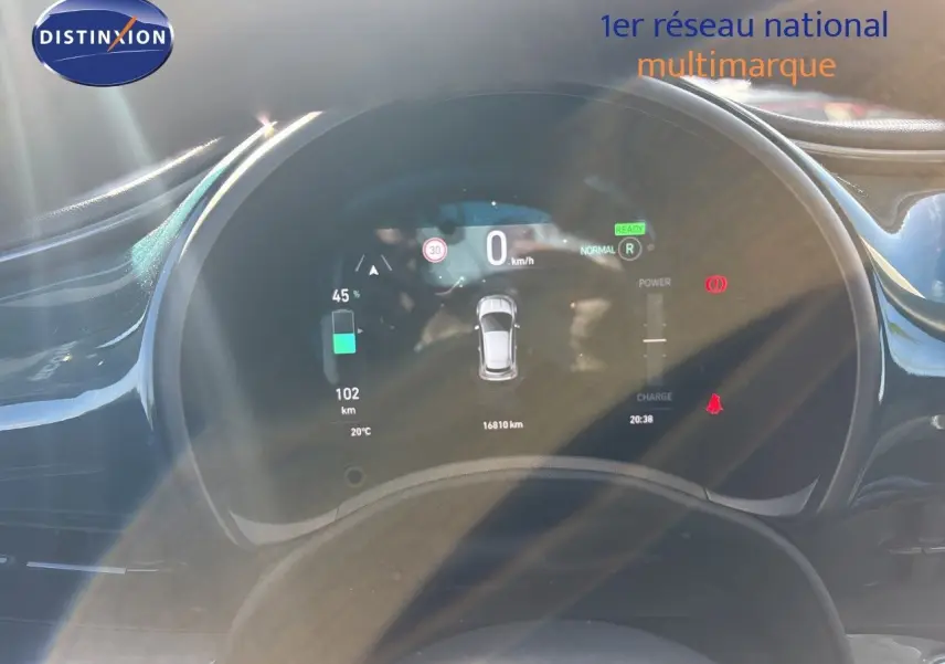 Vue rapprochée du tableau de bord numérique d'une Fiat 500 électrique 2023, affichant l'autonomie et la vitesse.