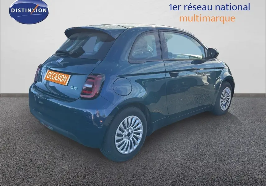 Vue 3/4 arrière droite d'une FIAT 500 électrique 2023 en vert océan métal avec jantes argentées et feux arrière LED.