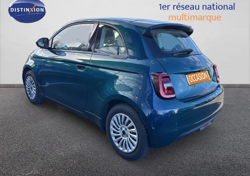 Vue 3/4 arrière droite d'une FIAT 500 électrique 2023 en vert océan métallisé avec jantes multibranches et feux arrière LED.