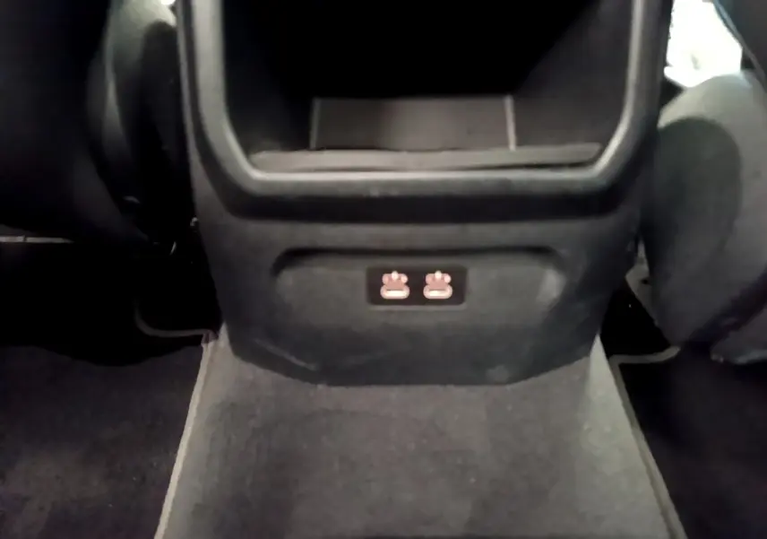 Vue rapprochée de la console centrale arrière noire avec prises USB dans une BMW Série 1 bleu Edition Sport 2023.