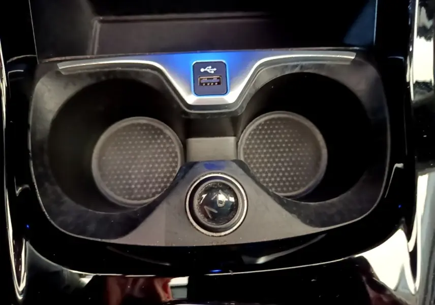 Gros plan sur les porte-gobelets et prise USB au centre de la console d’une BMW Série 1 118i Edition Sport bleue.