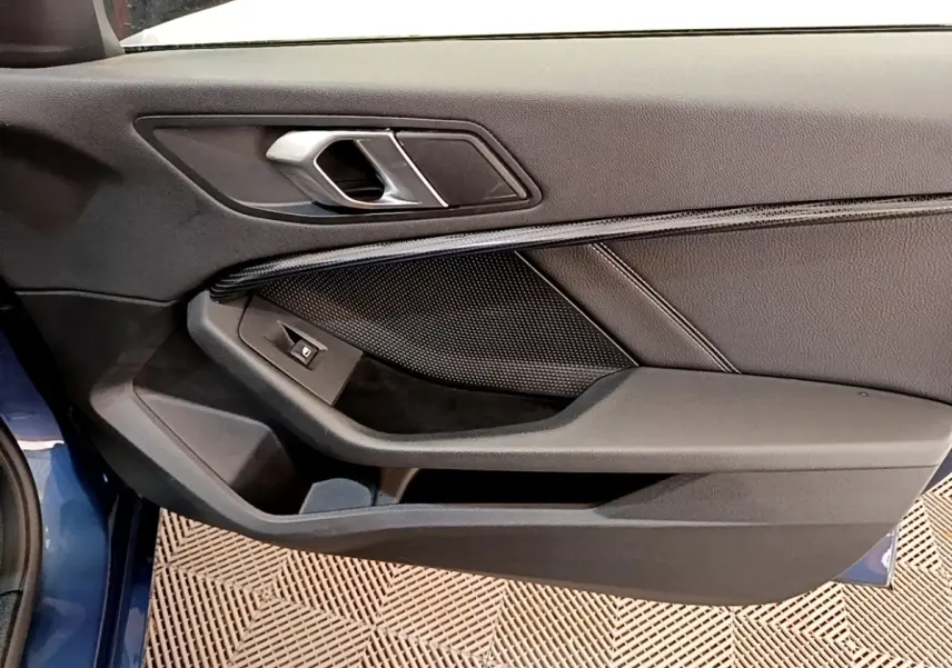 Vue rapprochée de la porte avant gauche bleu foncé de la BMW Série 1 118i Edition Sport avec poignée argentée.