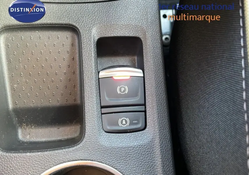 Gros plan sur les commandes de frein à main électronique et auto-hold dans l'habitacle du Renault Symbioz gris cassiopée.