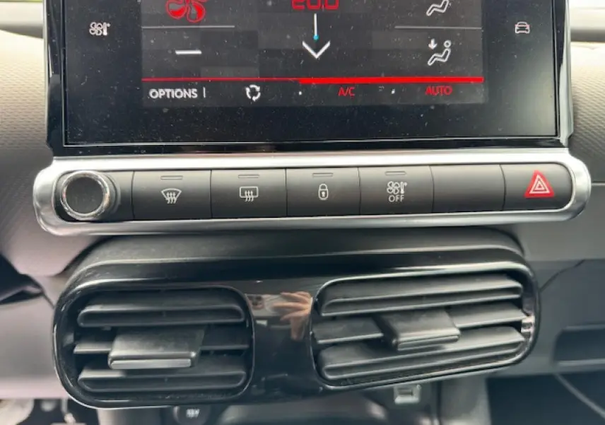 Gros plan sur la console centrale du Citroën C4 Cactus 2020, montrant l'écran tactile et les commandes de climatisation.