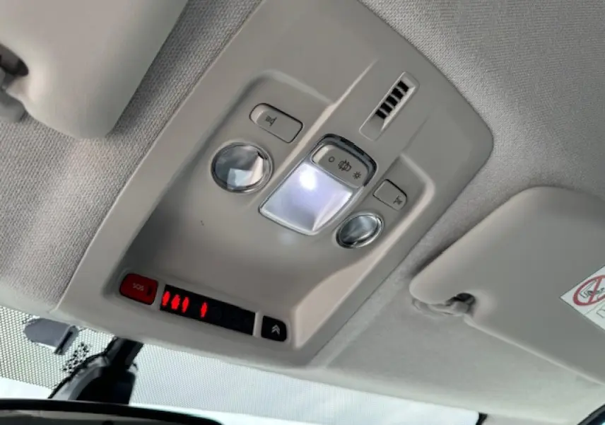 Vue intérieure du plafonnier gris clair du Citroën C4 Cactus 2020 avec éclairage et bouton SOS rouge allumé.
