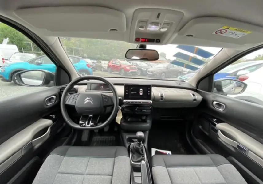 Intérieur de la Citroën C4 Cactus 2020 gris clair, vue frontale du tableau de bord avec volant et écran tactile.