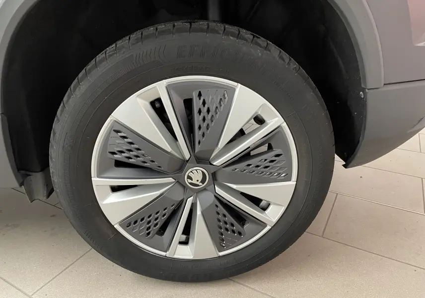 Gros plan sur la roue avant gauche du Skoda Karoq 2023 noir Magic Nacre avec jante au design moderne gris et argent.