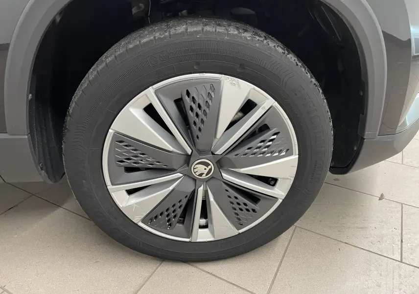 Gros plan sur la roue avant gauche du Skoda Karoq noir Magic nacré, avec jante alliage au design moderne.