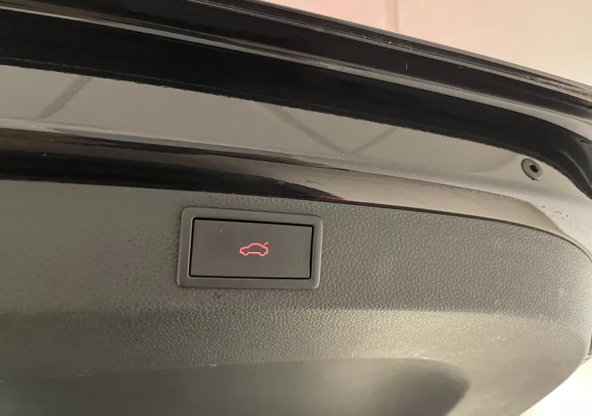 Bouton d'ouverture électrique du coffre sur la trappe arrière d'un Skoda Karoq noir Magic nacré 2023.