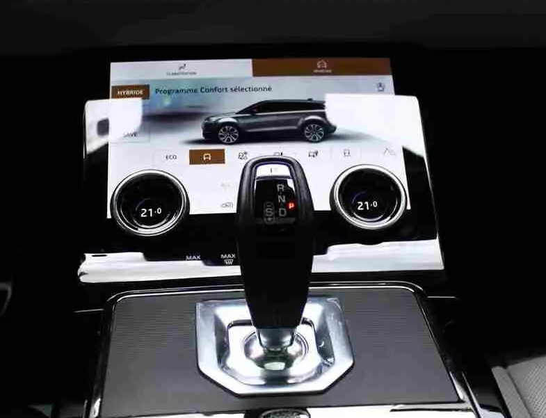 Vue intérieure centrée sur le volant gris clair et tableau de bord digital du Range Rover Evoque hybride rechargeable 2023.
