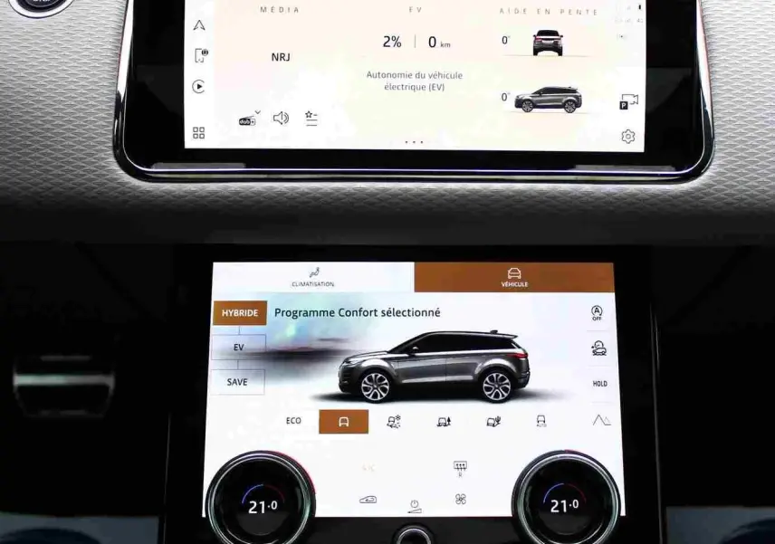 Vue rapprochée de la console centrale du Range Rover Evoque gris métal 2023 avec écran tactile et levier de vitesse moderne.