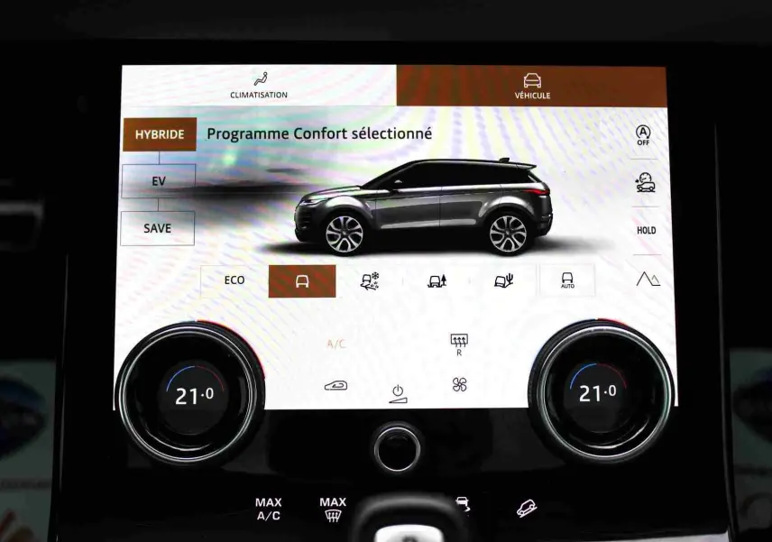 Gros plan intérieur sur la console centrale noire du Range Rover Evoque 2023, montrant prises USB et porte-gobelets.