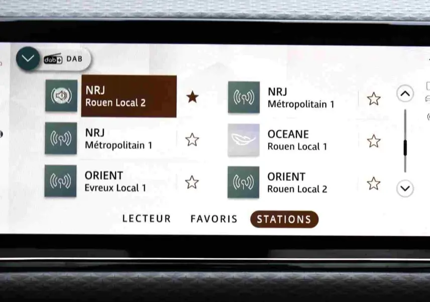 Écran tactile central du Range Rover Evoque 2023 gris métal, affichant navigation et lecteur multimédia.