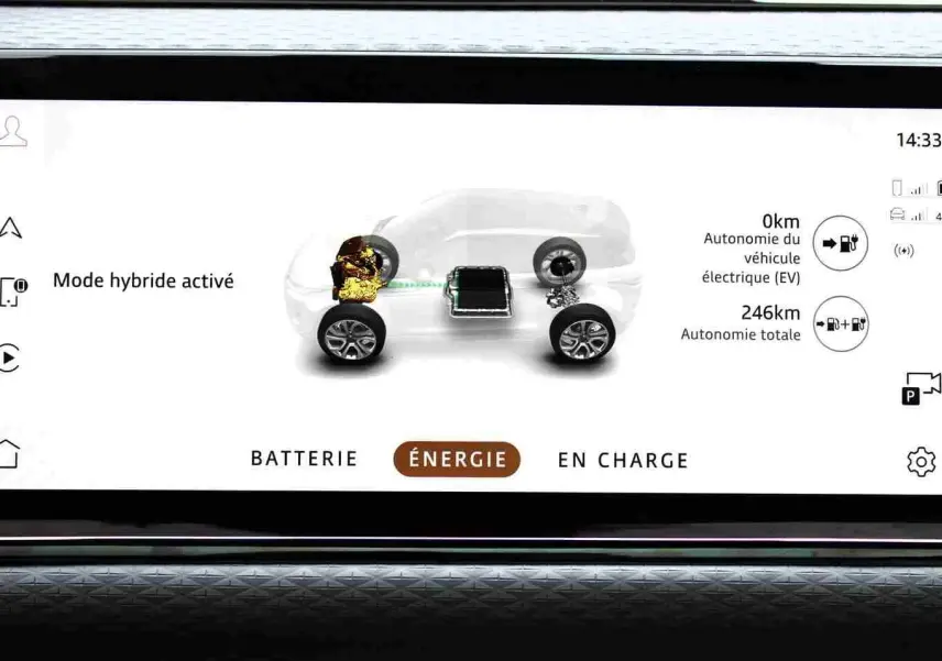 Écran tactile du tableau de bord du Range Rover Evoque 2023 gris métal, affichant l'autonomie électrique et l'aide en pente.
