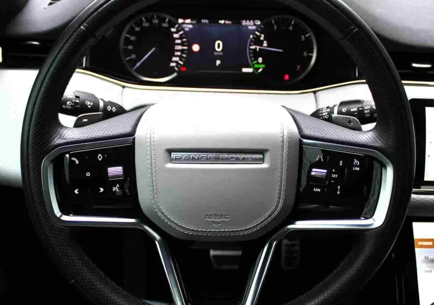 Vue de profil côté gauche du Range Rover Evoque 2023 gris métal, soulignant ses lignes épurées et ses jantes alliage.