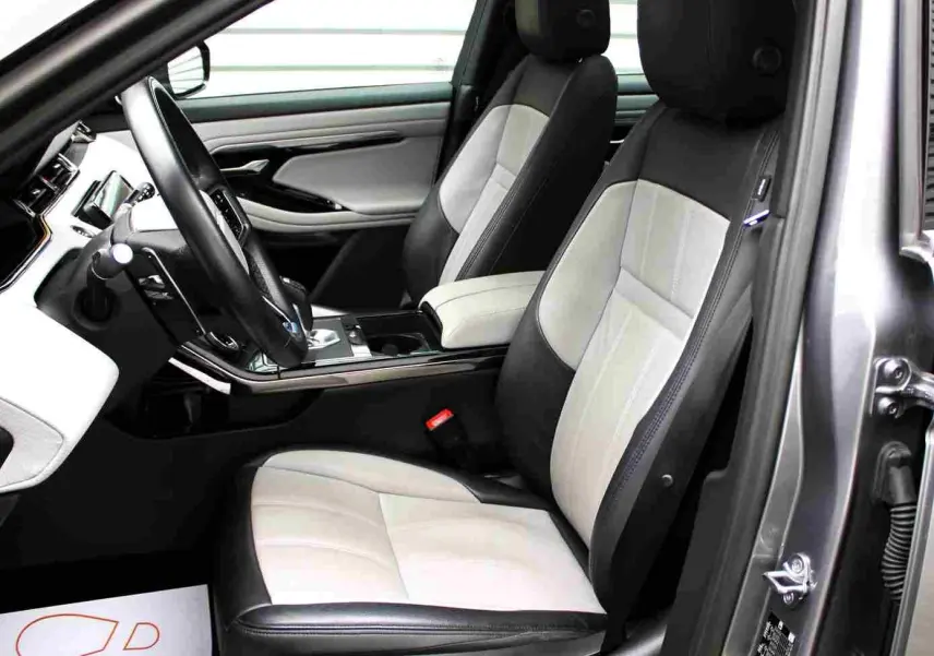 Vue 3/4 arrière droite d'un Range Rover Evoque gris métal 2023 hybride rechargeable avec plaque "OCCASION".