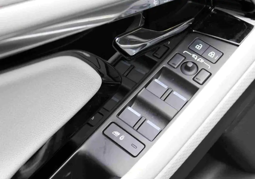 Vue rapprochée de la console centrale du Range Rover Evoque 2023 gris métal, affichant le mode hybride et la climatisation.