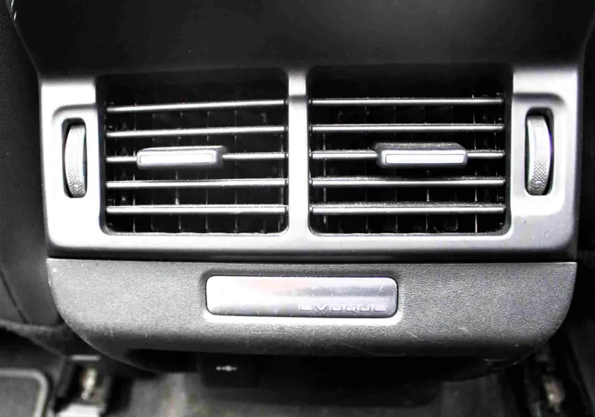 Écran tactile intérieur du Range Rover Evoque 2023 gris métal, affichant les réglages climatisation et modes hybrides.