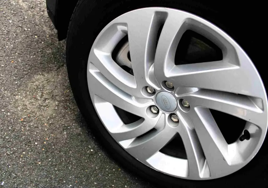 Gros plan sur la jante argentée du Range Rover Evoque 2023, mettant en valeur le logo Land Rover au centre.